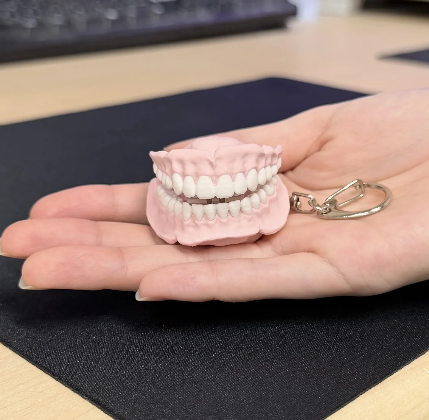 手のひらの上に置かれた入れ歯クリッカーキーホルダー