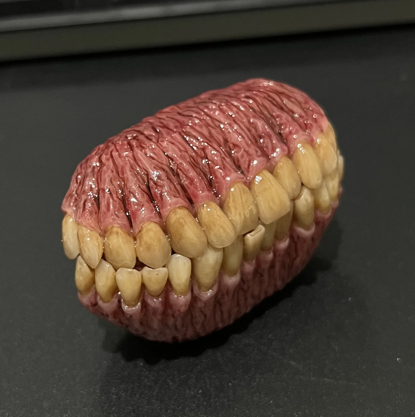 蓋を閉じた状態の、歯と歯根をモチーフにしたイヤホンケース