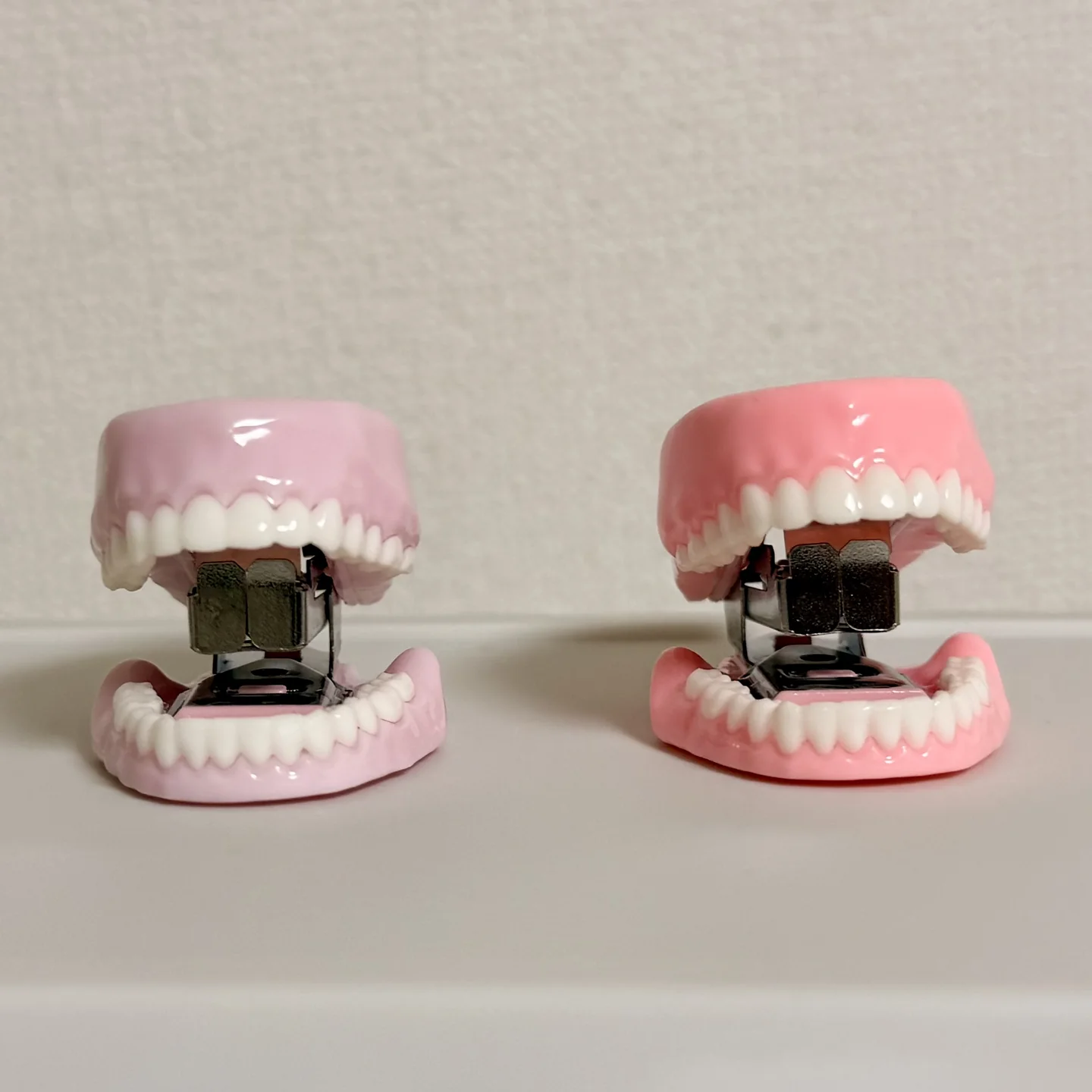 口を開けたピンク色の歯ッチキスが2つ並ぶ