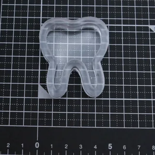 モールドから取り出した、内側にくぼみのある透明な歯形パーツの制作例